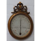 A 19th century French giltwood framed oval wall barometer with central alcohol thermometer, the