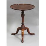 A George I and later mahogany and walnut circular wine table, on a turned baluster stem and tripod