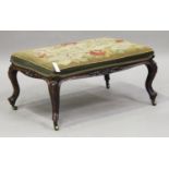 A mid-Victorian rosewood rectangular stool, the needlework seat above a carved frieze, raised on