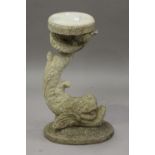 A 20th century cast composition stone garden stand in the form of a Regency dolphin, height 62cm.