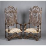 A pair of late 19th/early 20th century French carved walnut throne chairs, profusely carved with