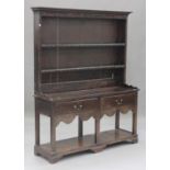 A late 18th century oak dresser, the shelf back above two frieze drawers and an open shelf, on