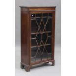 An Edwardian mahogany bookcase, the dentil moulded pediment above a single astragal glazed door,