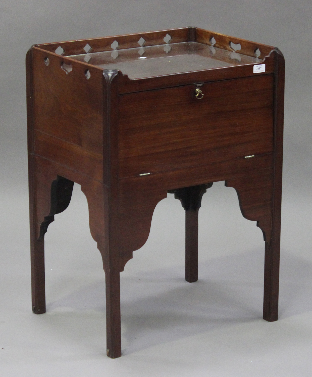 A 19th century mahogany night table with a pierced gallery top, the fall front raised on block legs,