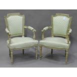 A pair of early 20th century Louis XVI style French cream and green painted fauteuil armchairs, each