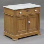 A late 19th century stripped pine washstand with marble top, fitted with a drawer and a pair of