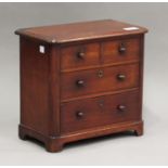 A mid-Victorian mahogany diminutive table-top chest of three long drawers, on bracket feet, height