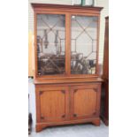 A late Victorian mahogany bookcase cabinet, the dentil moulded pediment above a pair of astragal