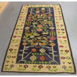 A Romanian kelhim rug, mid/late 20th century, the mid blue field with overall geometric flowers,