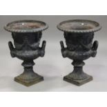 A pair of 20th century cast iron garden urns of half-reeded campana form, the bodies with floral