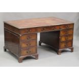 A 20th century reproduction mahogany twin pedestal desk, the top inset with a gilt-tooled red