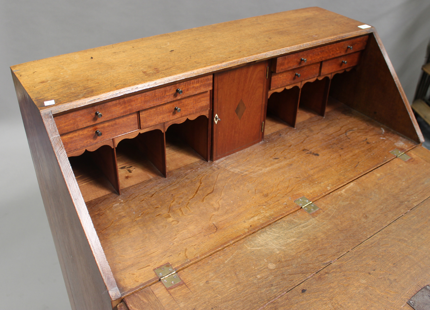 A George III oak bureau, crossbanded in mahogany, the fall flap revealing a fitted interior above - Image 2 of 2