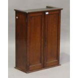 A late Victorian mahogany cabinet, fitted with a pair of panel doors revealing shelves and