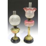 A late Victorian brass table oil lamp with an acid etched glass shade and pink glass reservoir,