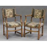 A pair of mid-20th century oak framed elbow chairs, probably retailed by Liberty & Co, the