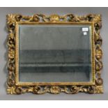 A late 19th century Florentine giltwood rectangular wall mirror with shell and scroll decoration,