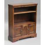 A 20th century oak open bookcase, fitted with an adjustable shelf above a pair of panel cupboard