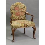 An early 20th century George I style walnut shepherd's crook elbow chair, upholstered in floral