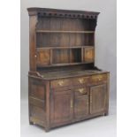 An 18th century oak dresser, the shelf back fitted with two cupboards, the base fitted with four
