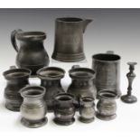 A collection of mainly 19th century pewter tankards and measures, including a pint tankard inscribed