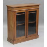 A late Victorian walnut bookcase enclosed by two glazed doors, on a plinth base, height 100cm, width