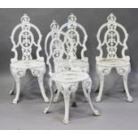 A set of four 20th century cast aluminium garden chairs, the pierced foliate backs on downswept