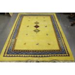 A Persian gabbeh rug, late 20th century, the sparsely decorated yellow field within a blue border,