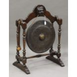 An early/mid-20th century oak framed gong stand, on turned and block supports, fitted with a