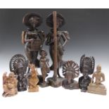 A pair of Balinese carved hardwood figures of two women, height 55cm, together with a small group of