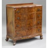 A George V burr walnut serpentine fronted chest of four graduated long drawers, on scroll feet,