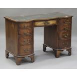 A 20th century mahogany serpentine fronted twin pedestal desk, the top inset with a gilt-tooled