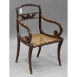 A Regency stained beech scroll arm elbow chair with cane seat, on sabre legs, height 86cm, width