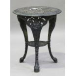 A Victorian cast iron circular garden table, the pierced top on three figural legs united by an