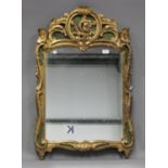 A 20th century French Rococo style giltwood and green painted wall mirror with carved foliate scroll