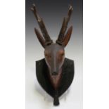 A 19th century Continental carved and stained wooden model of a deer's head, mounted on a wall