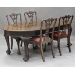 A George V mahogany extending dining table, fitted with two extra leaves, on carved cabriole legs