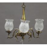 A late Victorian brass three-branch ceiling light with applied scrolling mounts and later glass