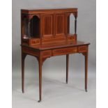 An Edwardian mahogany and satinwood crossbanded writing desk, the central cupboard revealing a