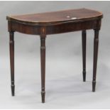 A George III mahogany fold-over tea table with inlaid shell paterae, on ring turned tapering legs,