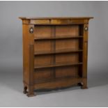 An Edwardian Arts and Crafts oak open bookcase, in the manner of Liberty & Co, the canopied top