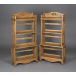 A very near pair of Edwardian Arts and Crafts oak four-tier open bookcases, attributed to Wylie &