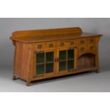 An Edwardian Arts and Crafts oak sideboard, possibly by Liberty & Co, the raised gallery back