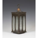 An early 20th century Arts and Crafts anodized copper hall lantern, the shaped top pierced with