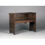 An early 20th century Arts and Crafts style stained oak hall bench, possibly by Liberty & Co, the