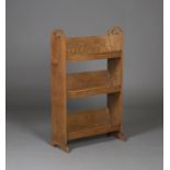 An early 20th century Arts and Crafts oak book trough, the sides with pierced carrying handles above