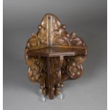 A late 19th/early 20th century Arts and Crafts oak corner shelf, finely carved with Tudor style