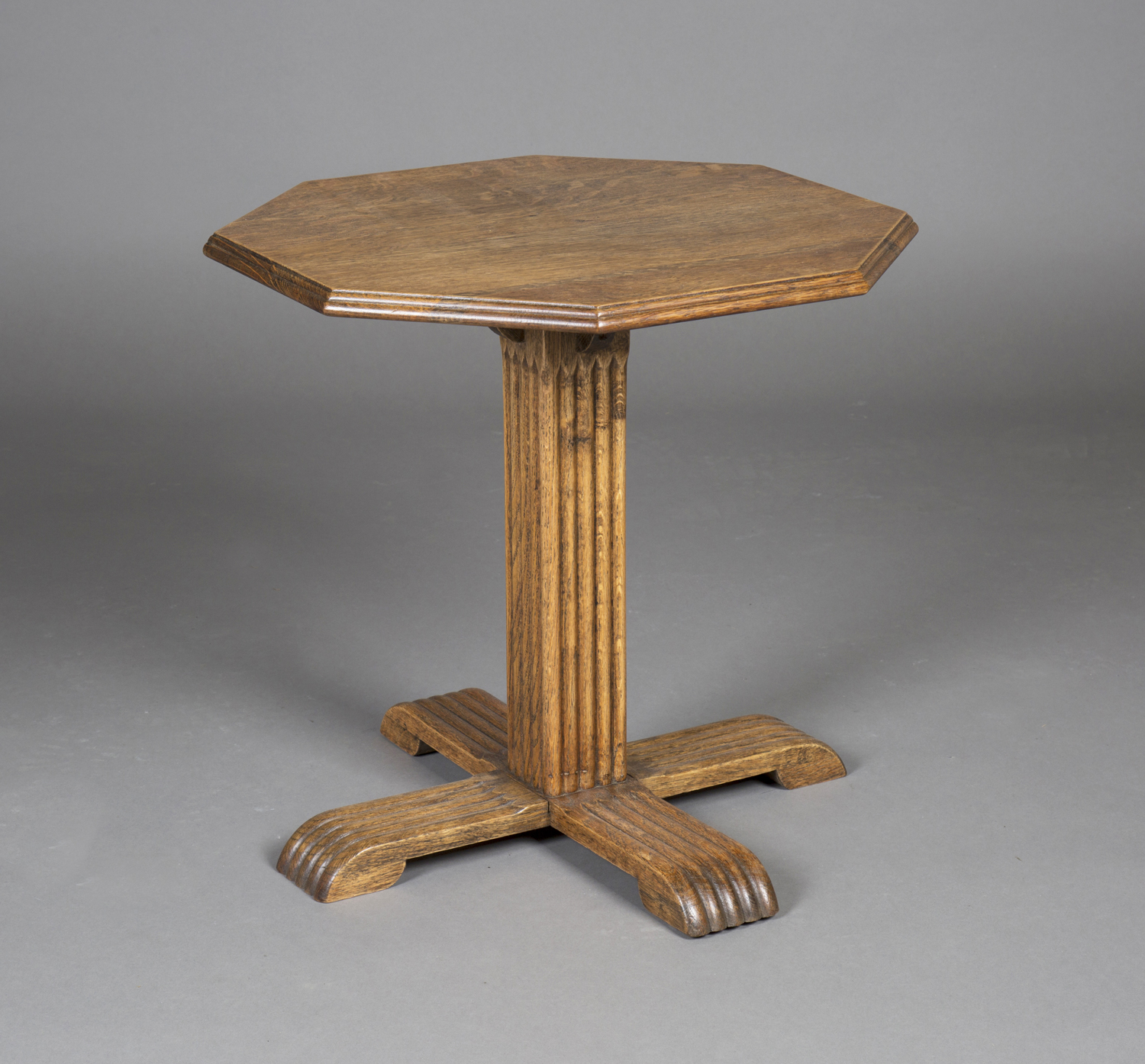 An early 20th century Heals style oak octagonal occasional table, the moulded top above a reeded