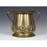 An Arts and Crafts brass coal bucket of ogee form, the body worked with scrolls, the sides with