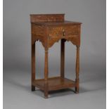 An Edwardian Arts and Crafts style oak side table, the raised gallery back above a single frieze