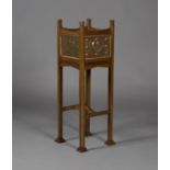 An Edwardian Arts and Crafts oak framed and copper inset jardinière stand, the square body inset